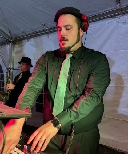 DJ TZ in headphones behind the booth