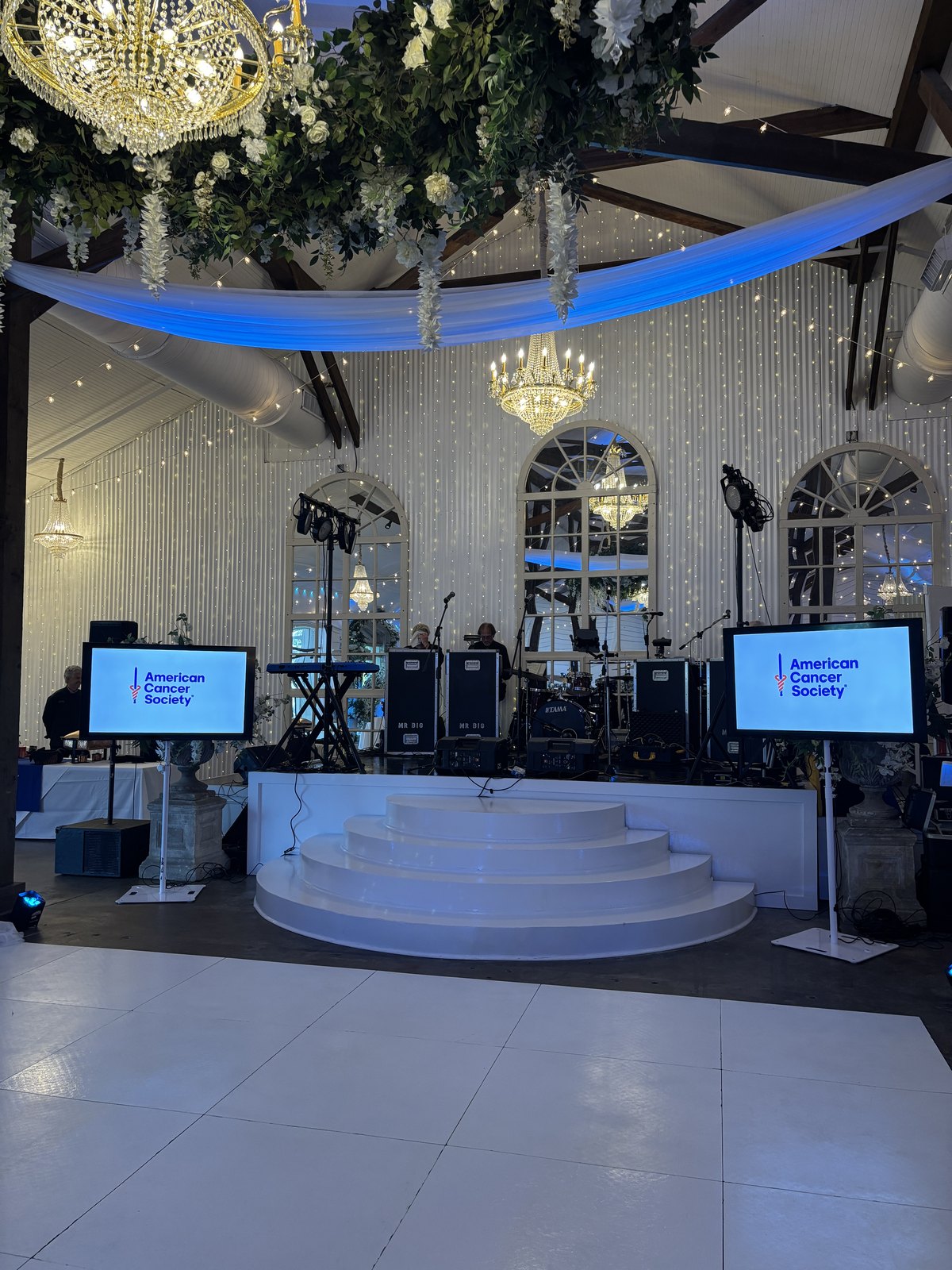Screens flanking a stage displaying event branding
