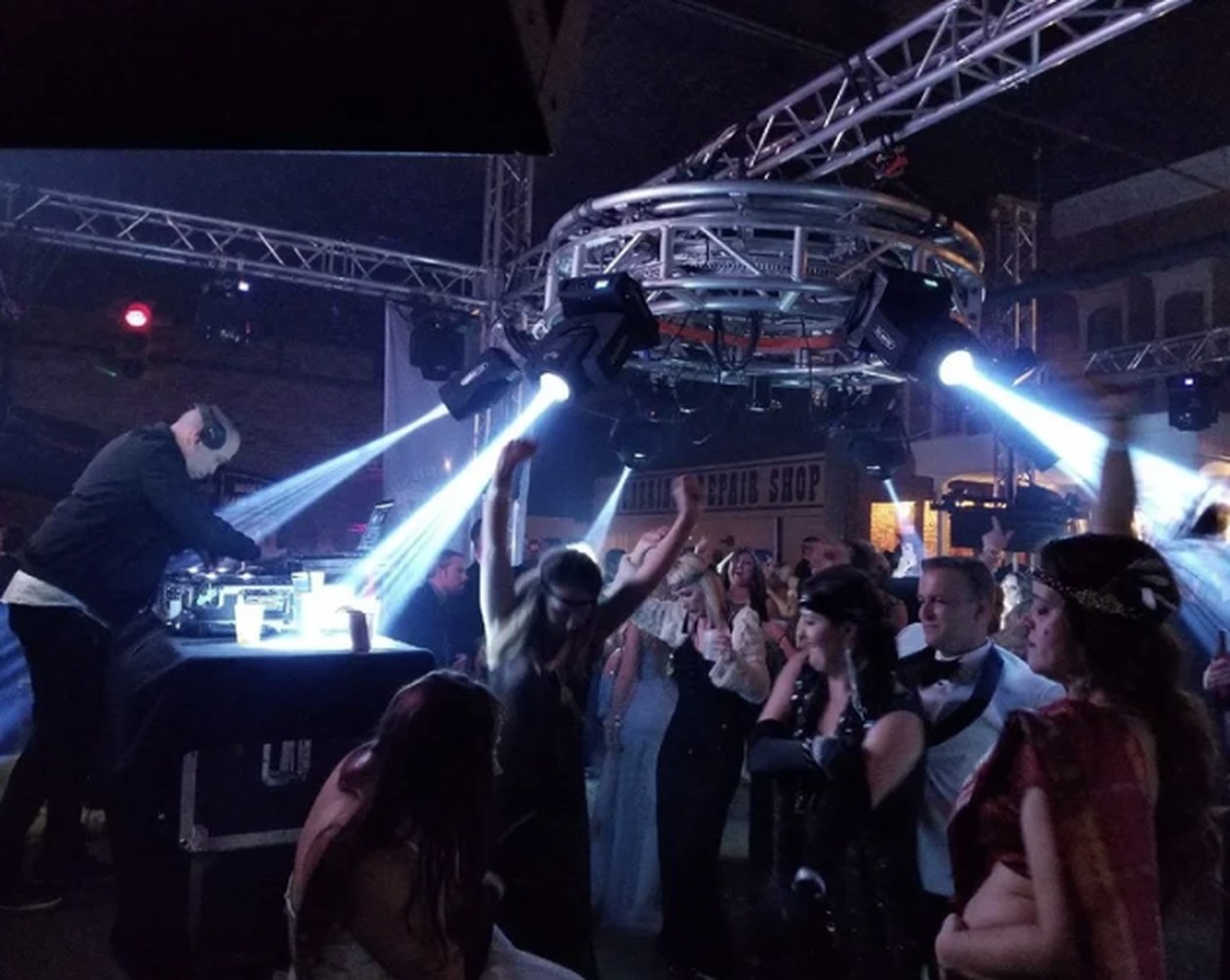 Packed New Year's Eve dance floor under moving-head lighting