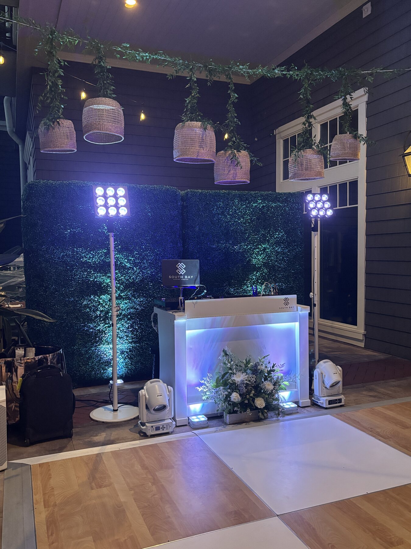 All-white setup against a hedge wall with florals